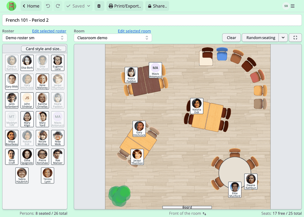 A screenshot of a school seating chart being created in Seating Chart Maker. The classroom has 25 seats in different kind of table groups. The classroom is a simple rectangle with a whiteboard at the front, with a wooden floor and a decorative plant. Person cards show person names and portraits and visually indicate where the person is seated.