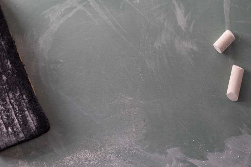 An empty chalkboard and couple of pieces of chalk.