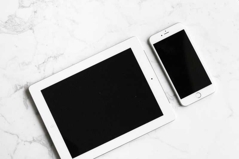 A tablet and a phone on a desk.